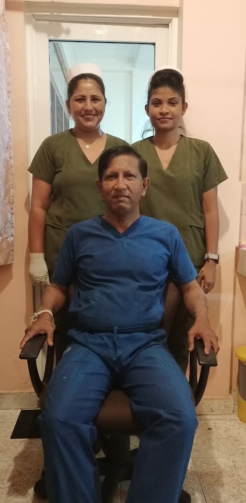 Dr. Asanga Goonathilake seated with two people in clinical scrubs